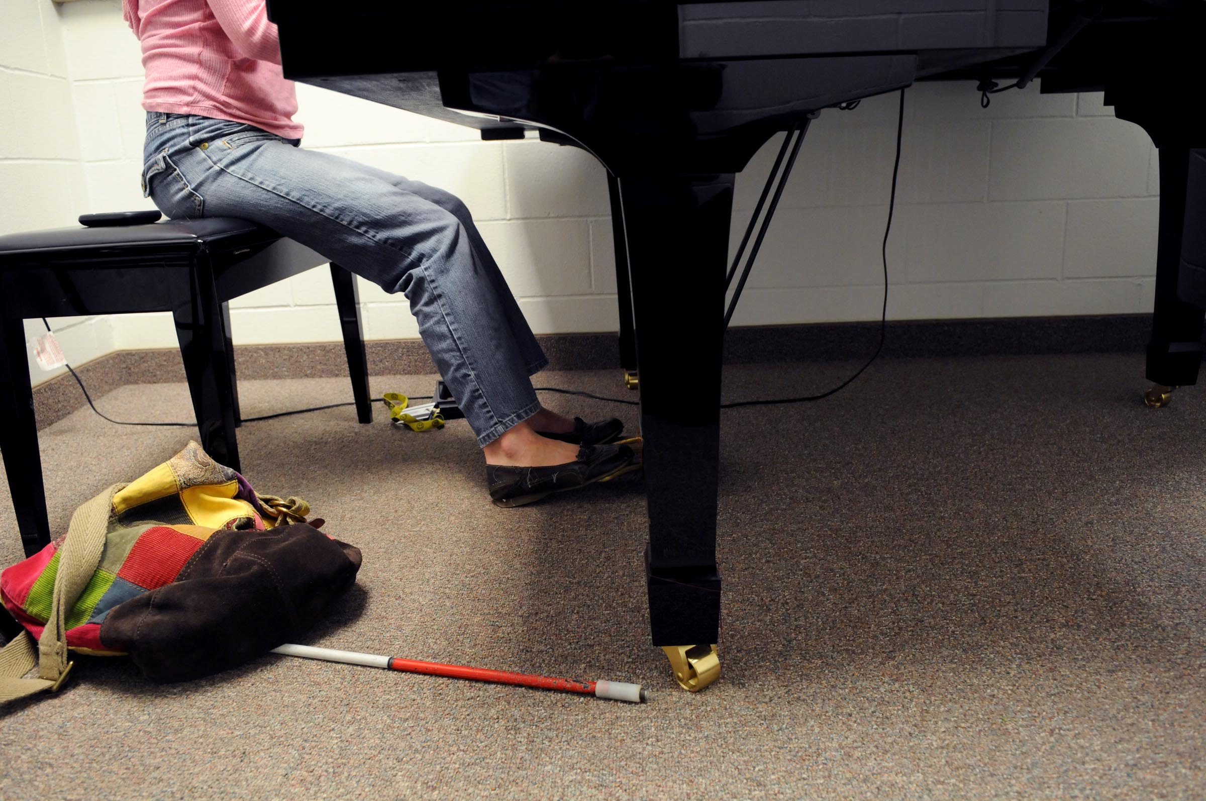 Piano player with white tipped cane